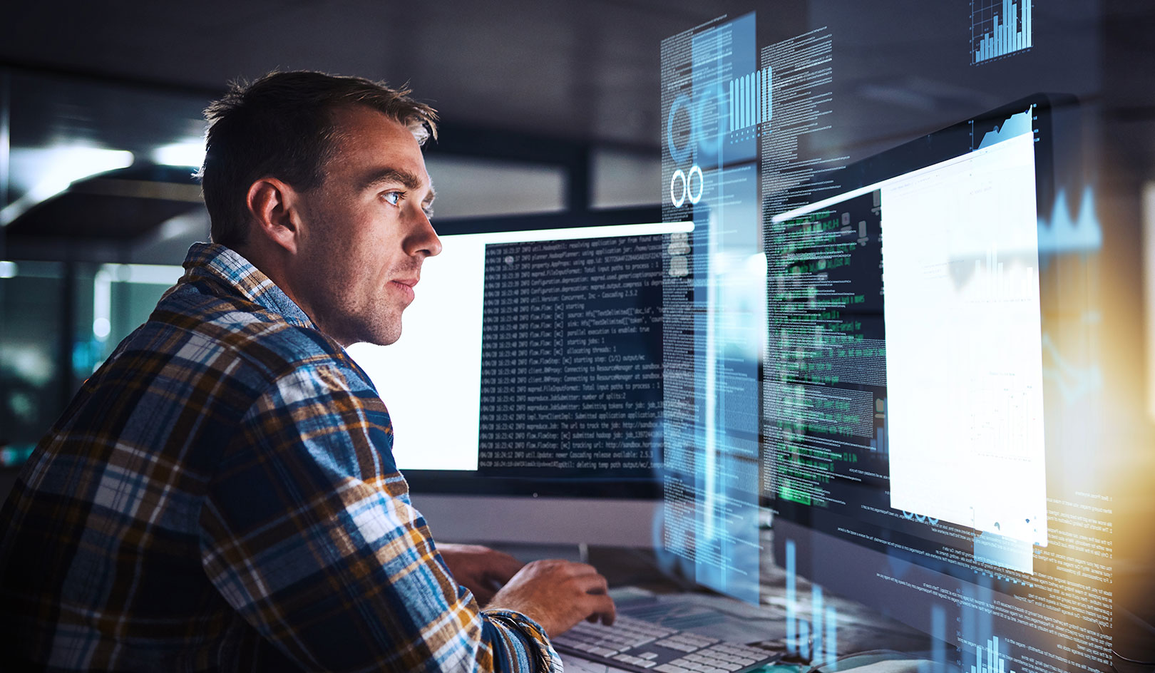 A man in a checkered shirt intently analyzing data on multiple computer screens with glowing graphs and lines of code.